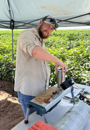 Plant Science graduate student Clay Christenson conducting midday leaf water uptake research